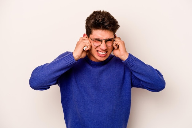 Young caucasian man isolated on white background covering ears with hands