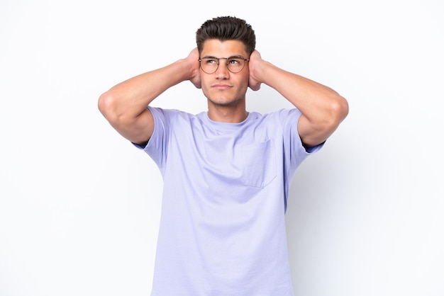 Young caucasian man isolated on white background frustrated and covering ears