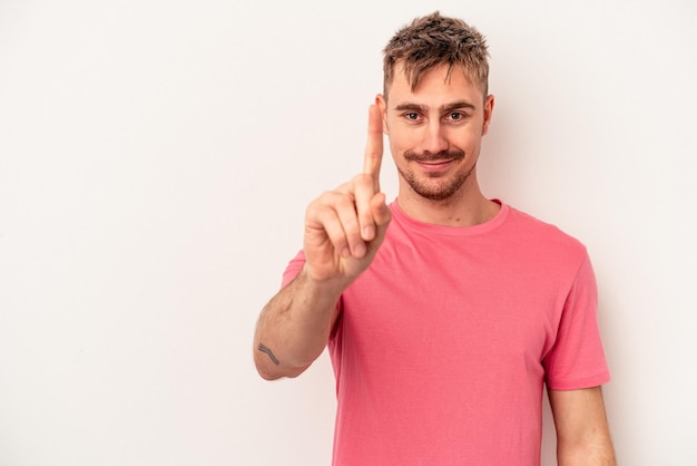 Young caucasian man isolated on white background holding and showing a product on hand.