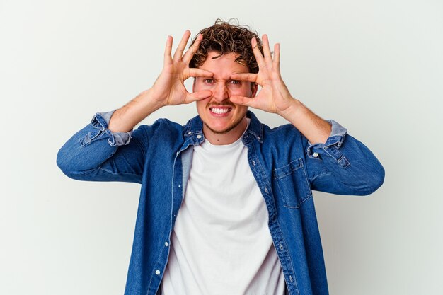 Young caucasian man isolated on white background keeping eyes opened to find a success opportunity.