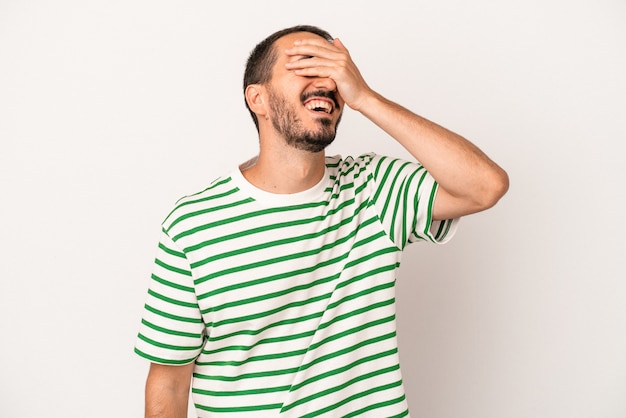 Young caucasian man isolated on white background laughs joyfully keeping hands on head. Happiness concept.