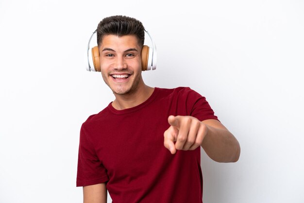 Young caucasian man isolated on white background listening music