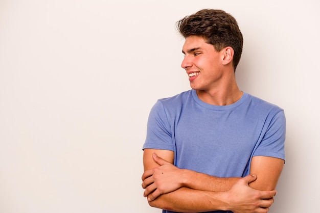 Young caucasian man isolated on white background smiling confident with crossed arms