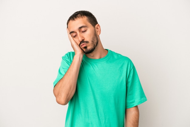 Young caucasian man isolated on white background who is bored, fatigued and need a relax day.