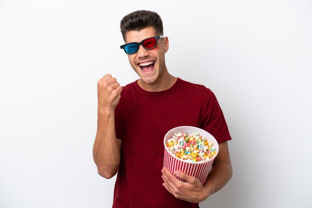 Young caucasian man isolated on white background with 3d glasses and holding a big bucket of popcorns