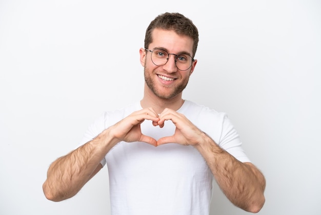 Young caucasian man isolated on white background With glasses making heart with hands