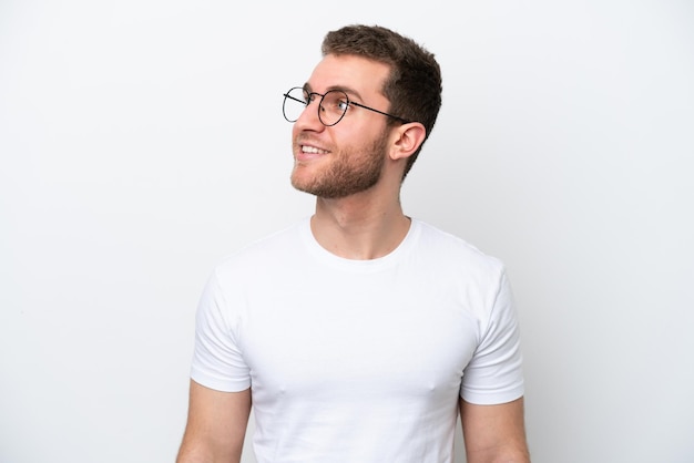 Young caucasian man isolated on white background With glasses with happy expression