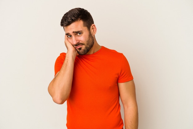 Young caucasian man isolated on white wall who is bored, fatigued and need a relax day