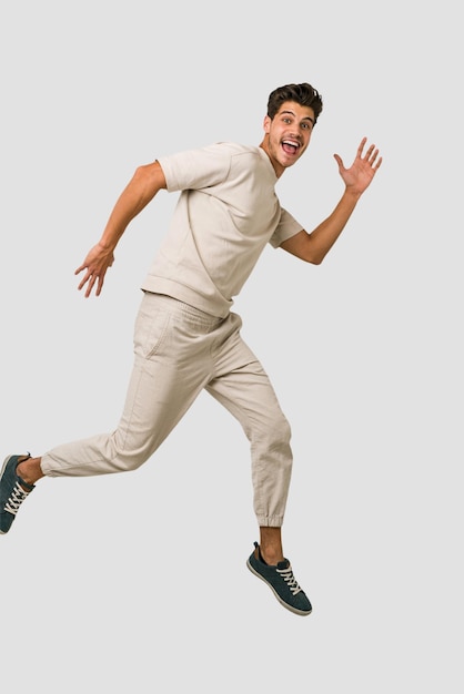 Young caucasian man jumping isolated on white background