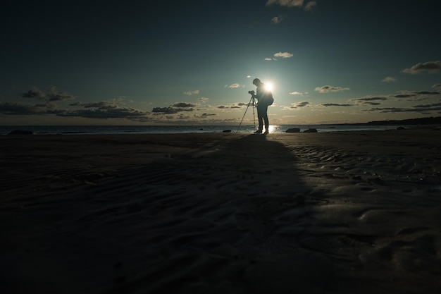 Young caucasian man making photo of landscape on seaside