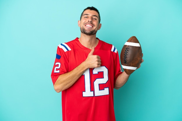 Young caucasian man playing rugby isolated on blue background giving a thumbs up gesture