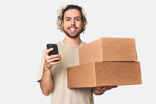 Young Caucasian man receiving packages on phone in studio