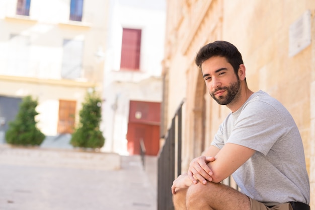 young caucasian man sitting in city