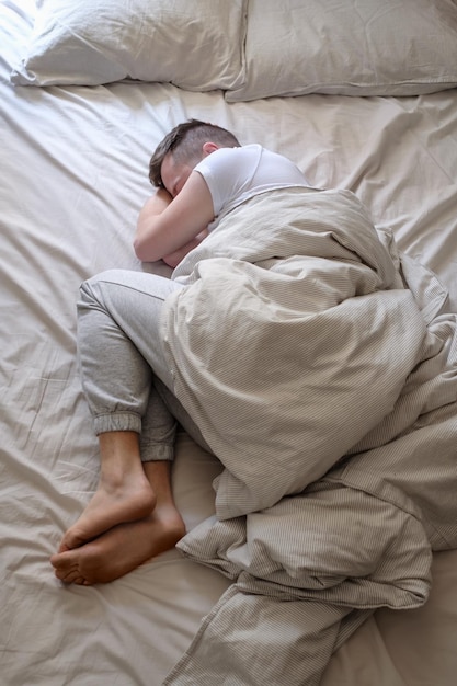 Young caucasian man sleeping in his bed