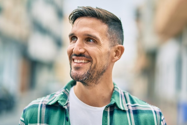 Young caucasian man smiling happy standing at the city