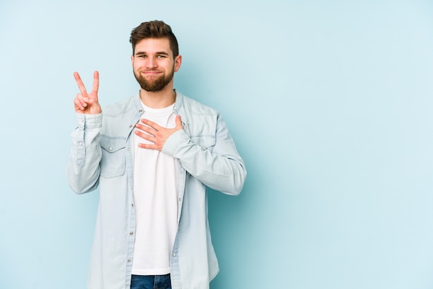 Young caucasian man taking an oath, putting hand on chest.