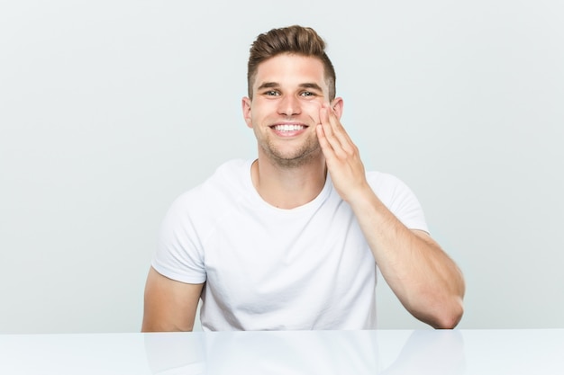 Young caucasian man using facial moisturizer