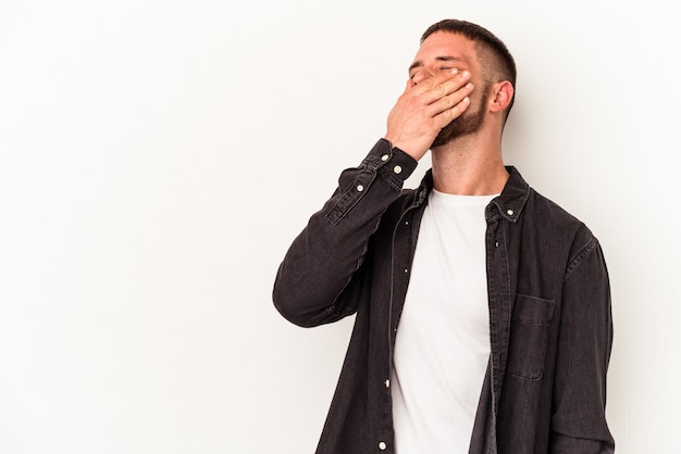 Young caucasian man with diastema isolated on white background laughing happy, carefree, natural emotion.