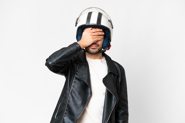 Young caucasian man with a motorcycle helmet over isolated white background covering eyes by hands Do not want to see something