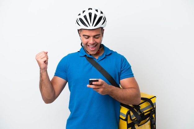 Young caucasian man with thermal backpack isolated on white background surprised and sending a message