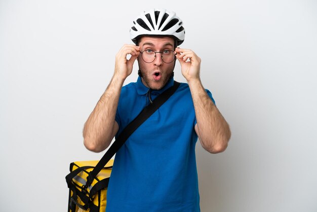 Young caucasian man with thermal backpack isolated on white background with glasses and surprised