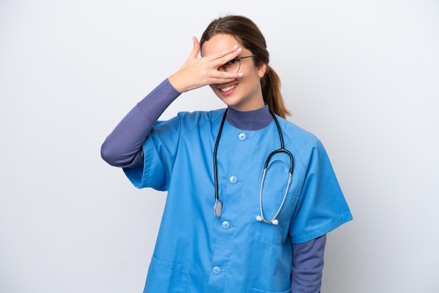 Young caucasian nurse woman isolated on white background covering eyes by hands and smiling