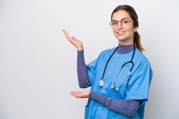 Young caucasian nurse woman isolated on white background extending hands to the side for inviting to come