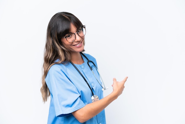 Young caucasian nurse woman isolated on white background pointing back