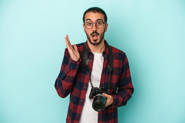 Photo young caucasian photographer man isolated on blue background surprised and shocked