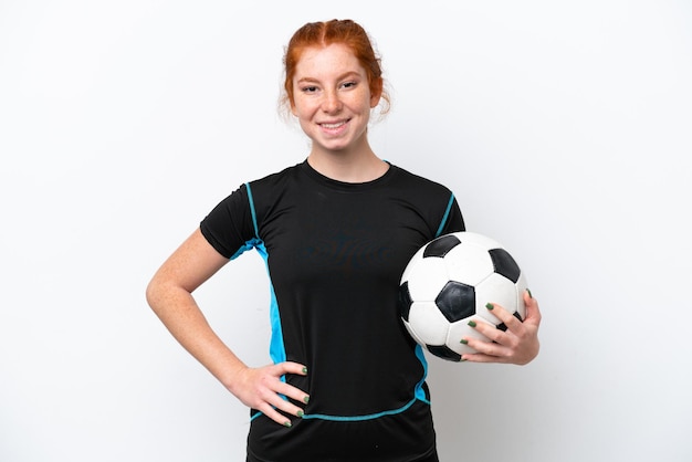 Young caucasian reddish football player woman isolated on white background posing with arms at hip and smiling