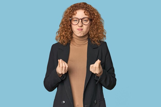 Young Caucasian redhead in business attire showing that she has no money