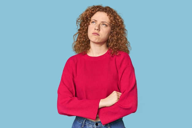 Young Caucasian redhead woman tired of a repetitive task