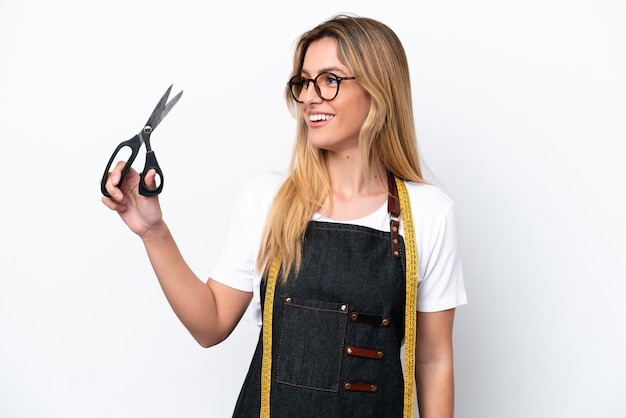 Young caucasian seamstress woman isolated on white background looking side