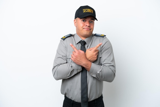 Young caucasian security man isolated on white background pointing to the laterals having doubts