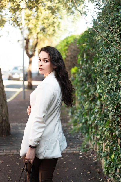 Young caucasian sexy business woman walking on a summer town street