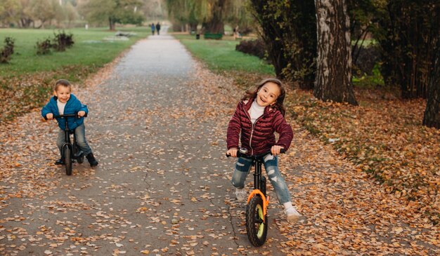 Young caucasian siblings riding their bikes in the park