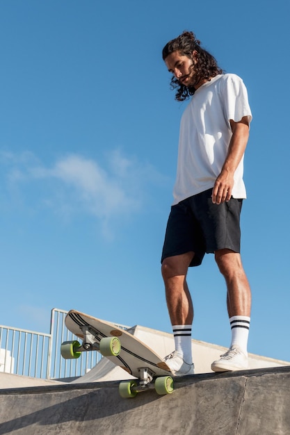 Young caucasian skater at the skate park ready to go down the skate ramp