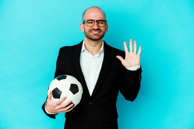 Young caucasian soccer trainer isolated on white wall smiling cheerful showing number five with fingers.