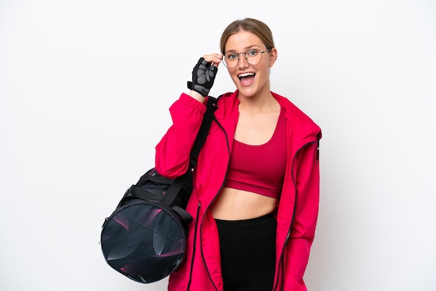 Young caucasian sport woman isolated on white background with glasses and surprised