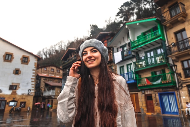 Young caucasian tourist woman using the smartphone in an old town.