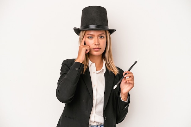 Young caucasian wizard woman holding wand isolated on white background pointing temple with finger, thinking, focused on a task.