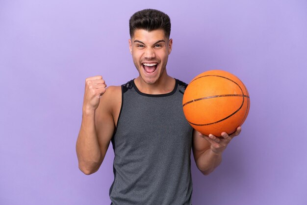 Young caucasian woman basketball player man isolated on purple background celebrating a victory in winner position