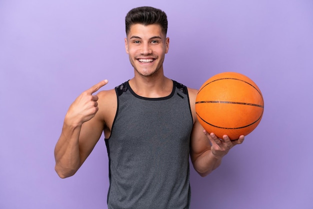 Young caucasian woman basketball player man isolated on purple background giving a thumbs up gesture