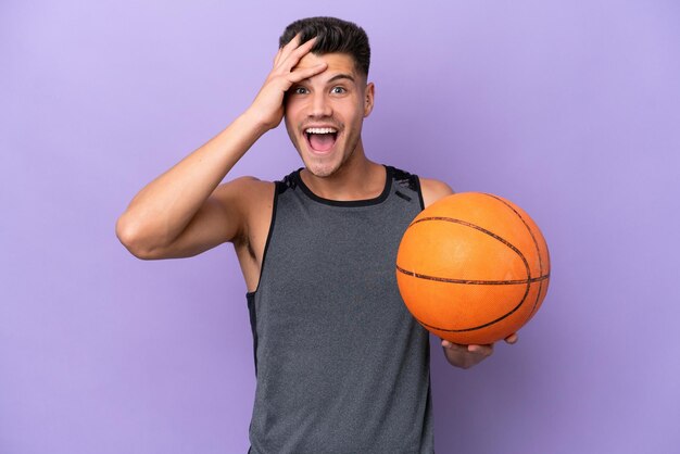 Young caucasian woman basketball player man isolated on purple background with surprise expression