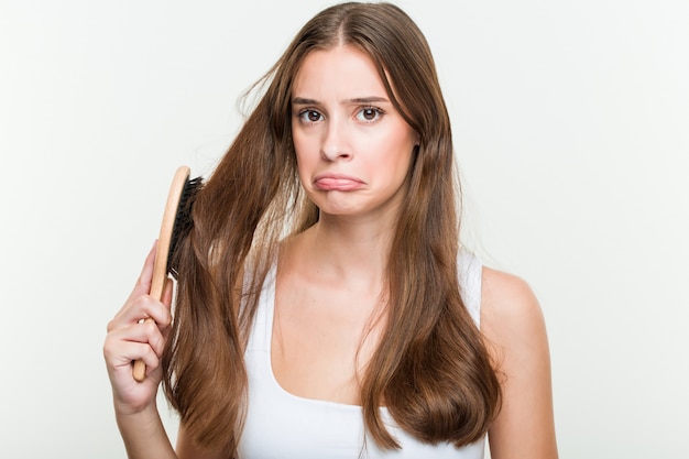 Young caucasian woman brushing her hair