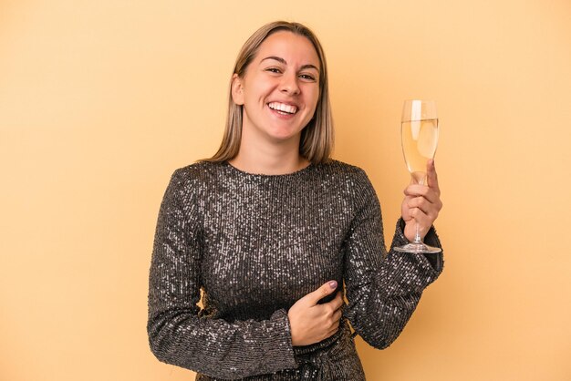 Young caucasian woman celebrating new year isolated on yellow background laughing and having fun.