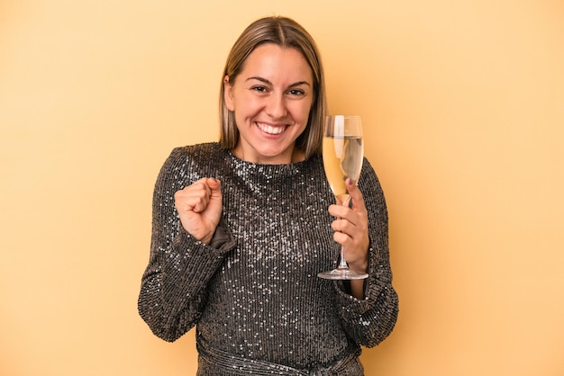 Young caucasian woman celebrating new year isolated on yellow background