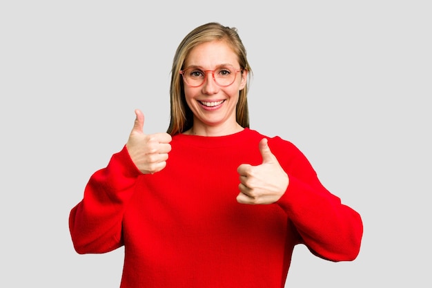 Photo young caucasian woman cutout isolated raising both thumbs up smiling and confident