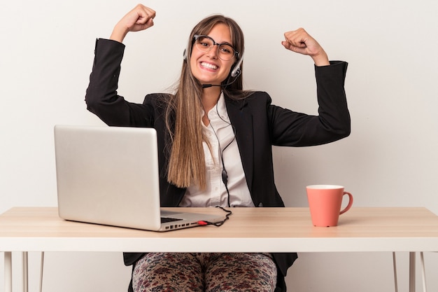 Young caucasian woman doing telecommuting isolated on white background showing strength gesture with arms, symbol of feminine power