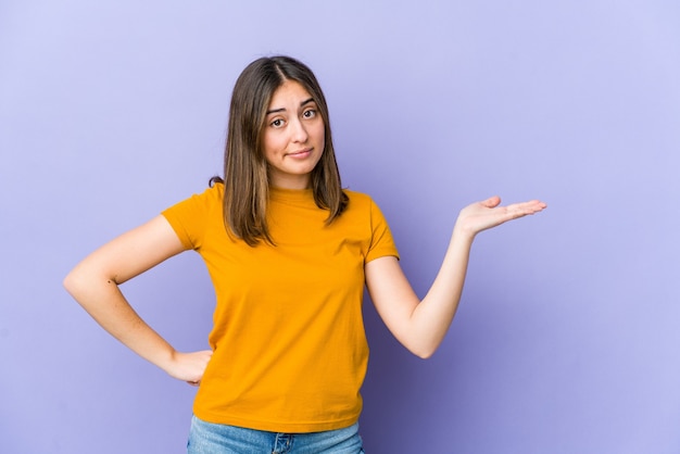 Young caucasian woman doubting and shrugging shoulders in questioning gesture.